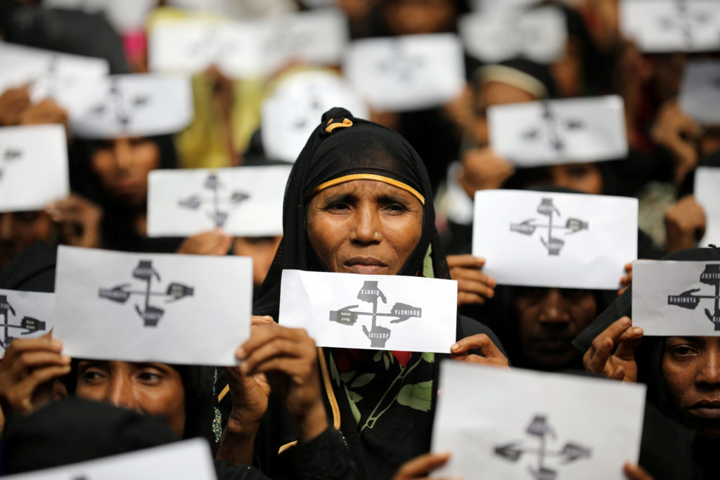 Rohingya community members holding signs during a march at Kutupalong refugee camp, Bangladesh
